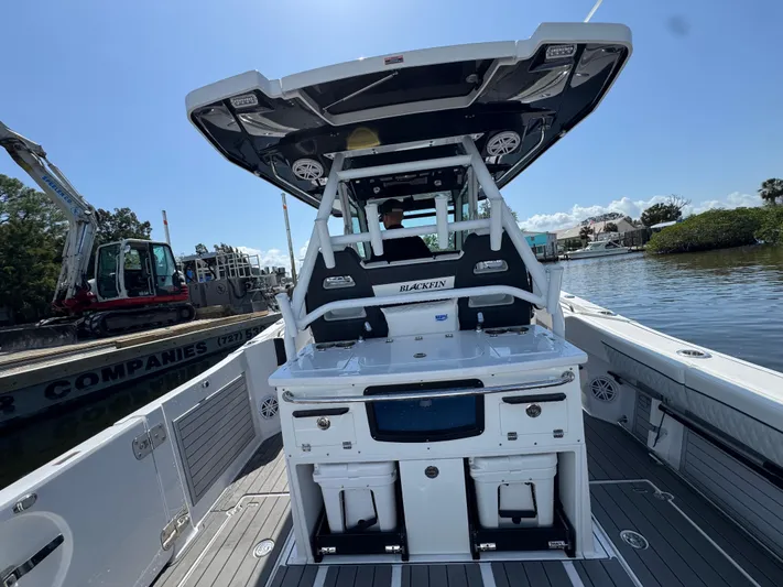  Yacht Photos Pics 2024 Blackfin 332 CC boat interior with fishing station and seating, docked by water.