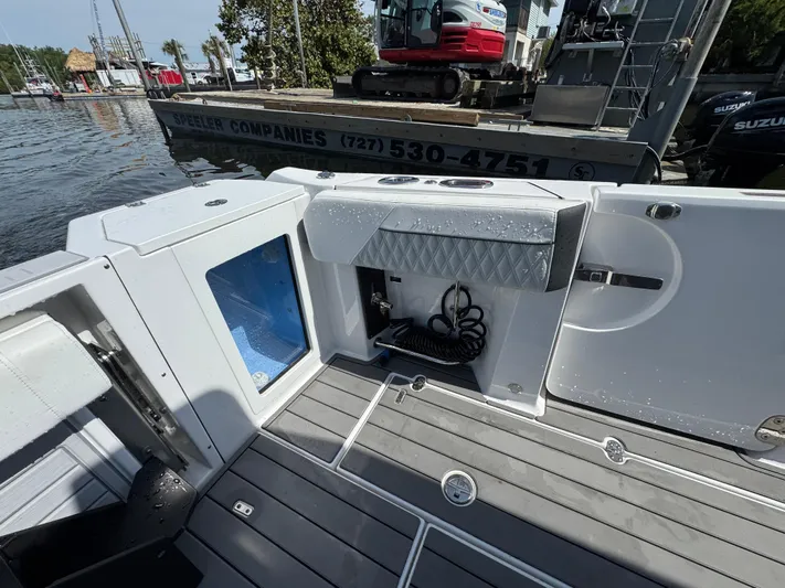  Yacht Photos Pics 2024 Blackfin 332 CC boat interior with storage compartments and coiled hose on deck.