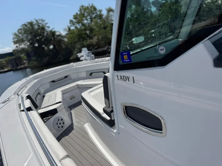  Yacht Photos Pics 2024 Blackfin 332 CC boat, sleek design, docked near lush greenery.