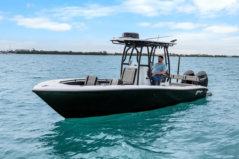  Yacht Photos Pics 2025 Yellowfin 26 Hybrid boat on clear blue water, under a partly cloudy sky.