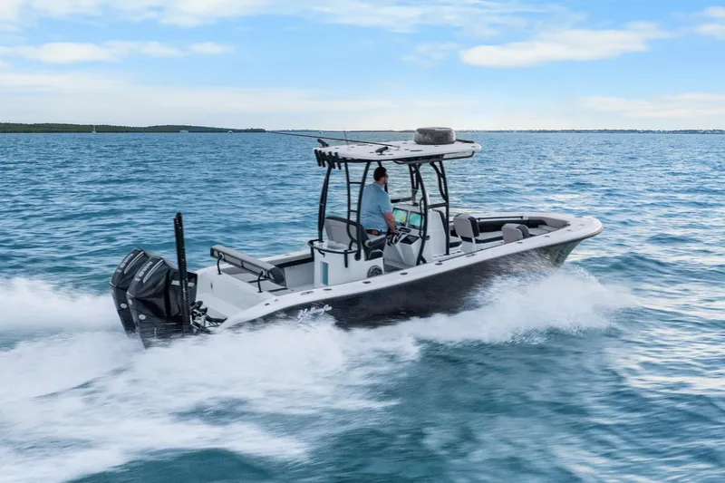  Yacht Photos Pics 2025 Yellowfin 26 Hybrid boat cruising on open water under a clear blue sky.