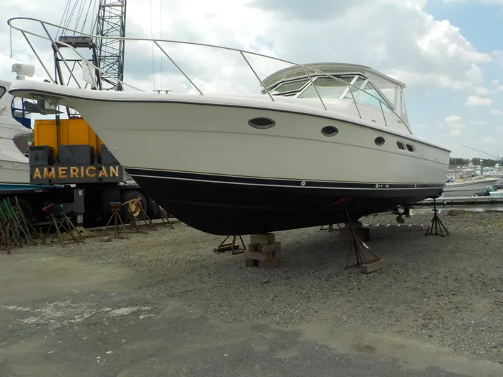 " Sea Goll " Yacht Photos Pics 2003 Tiara Yachts 3100 Open boat on dry dock, side view, under cloudy sky.
