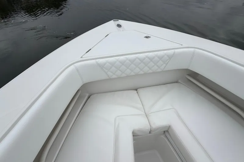  Yacht Photos Pics Bow seating area of a 2009 Jupiter 29 boat with white upholstery.