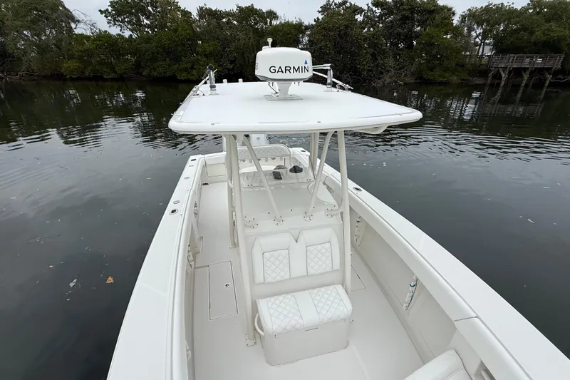  Yacht Photos Pics 2009 Jupiter 29 boat with Garmin equipment on calm water, surrounded by trees.