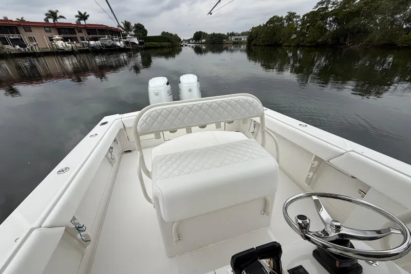  Yacht Photos Pics 2009 Jupiter 29 boat interior with white seating, steering wheel, and calm waterfront view.