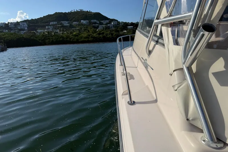  Yacht Photos Pics 2008 Grady-White Express 330 boat on calm water near lush hillside.