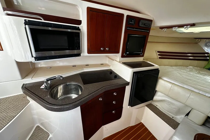  Yacht Photos Pics 2008 Grady-White Express 330 interior with kitchenette, featuring sink, microwave, and compact fridge.