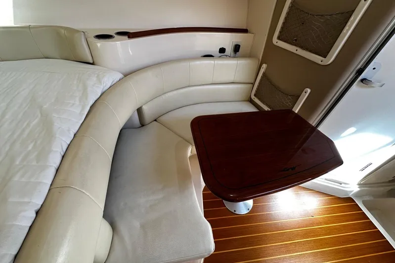  Yacht Photos Pics Interior of 2008 Grady-White Express 330 with cushioned seating and wooden table.