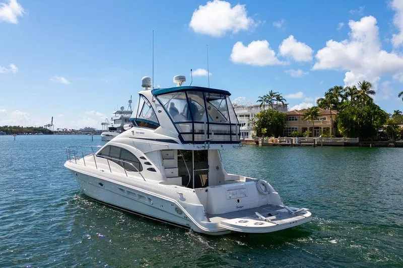 Lazy Days Yacht Photos Pics 2009 Sea Ray 44 Sedan Bridge yacht cruising on a sunny day near waterfront homes.