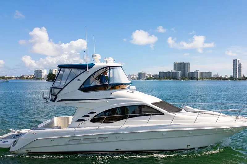Lazy Days Yacht Photos Pics 2009 Sea Ray 44 Sedan Bridge yacht cruising on a sunny day with city skyline.