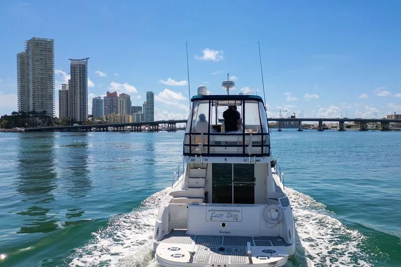 Lazy Days Yacht Photos Pics 2009 Sea Ray 44 Sedan Bridge cruising near city skyline and bridge.
