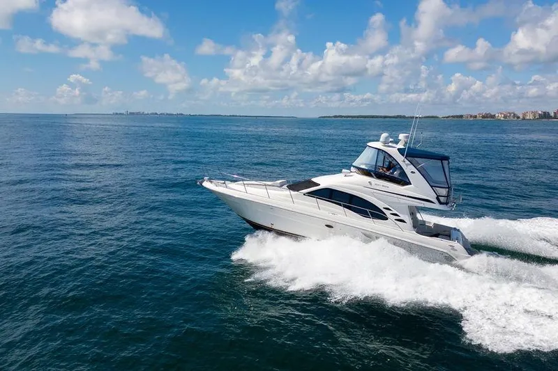 Lazy Days Yacht Photos Pics 2009 Sea Ray 44 Sedan Bridge yacht cruising on open water under a clear blue sky.