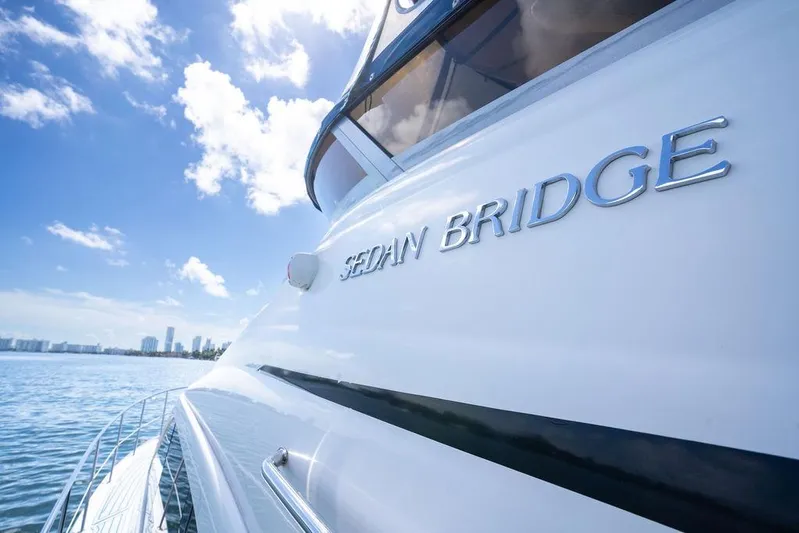 Lazy Days Yacht Photos Pics 2009 Sea Ray 44 Sedan Bridge yacht on a sunny day, city skyline in background.