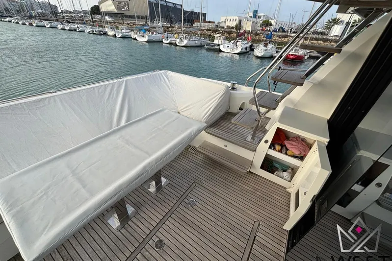 Albina Yacht Photos Pics 2018 Prestige 520 yacht deck with covered seating, marina view, and storage compartment.