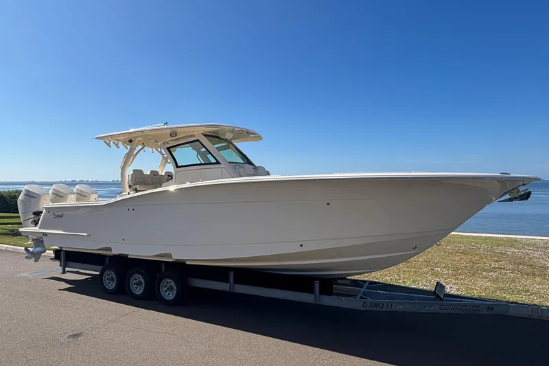  Yacht Photos Pics 2026 Scout 357 LXF boat on trailer by the waterfront under clear blue sky.