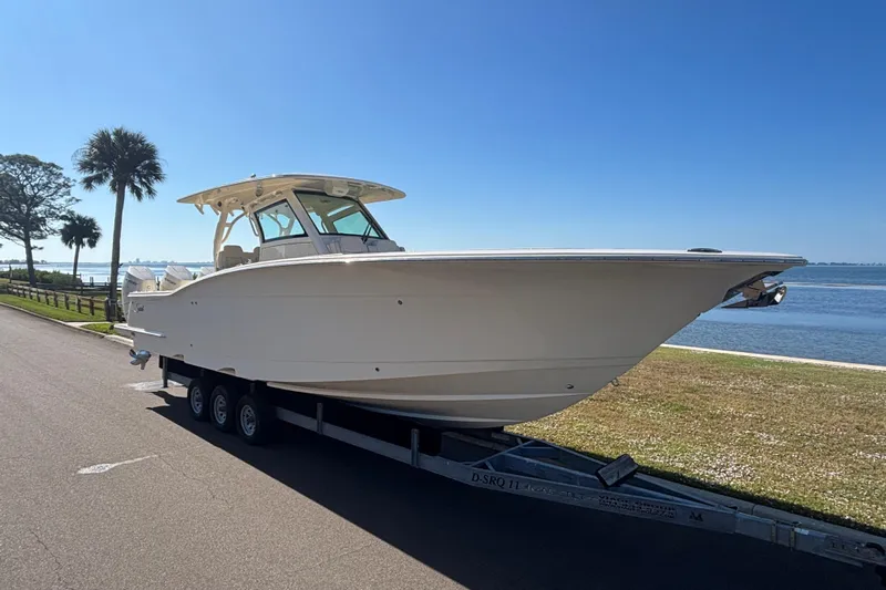  Yacht Photos Pics 2026 Scout 357 LXF boat on trailer by waterfront, clear blue sky.