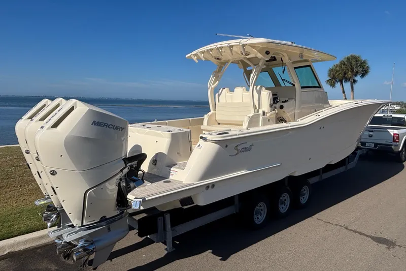  Yacht Photos Pics 2026 Scout 357 LXF boat with triple Mercury engines on a trailer by the water.
