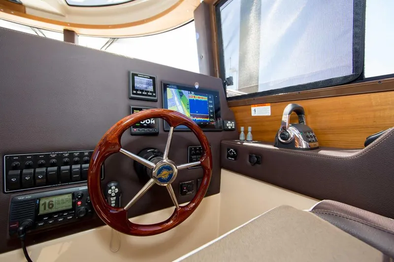 Poseidon&rsquo;s Lanai Yacht Photos Pics Manufacturer Provided Image: 2021 Ranger Tugs R-29 CB helm with navigation equipment and wooden steering wheel.