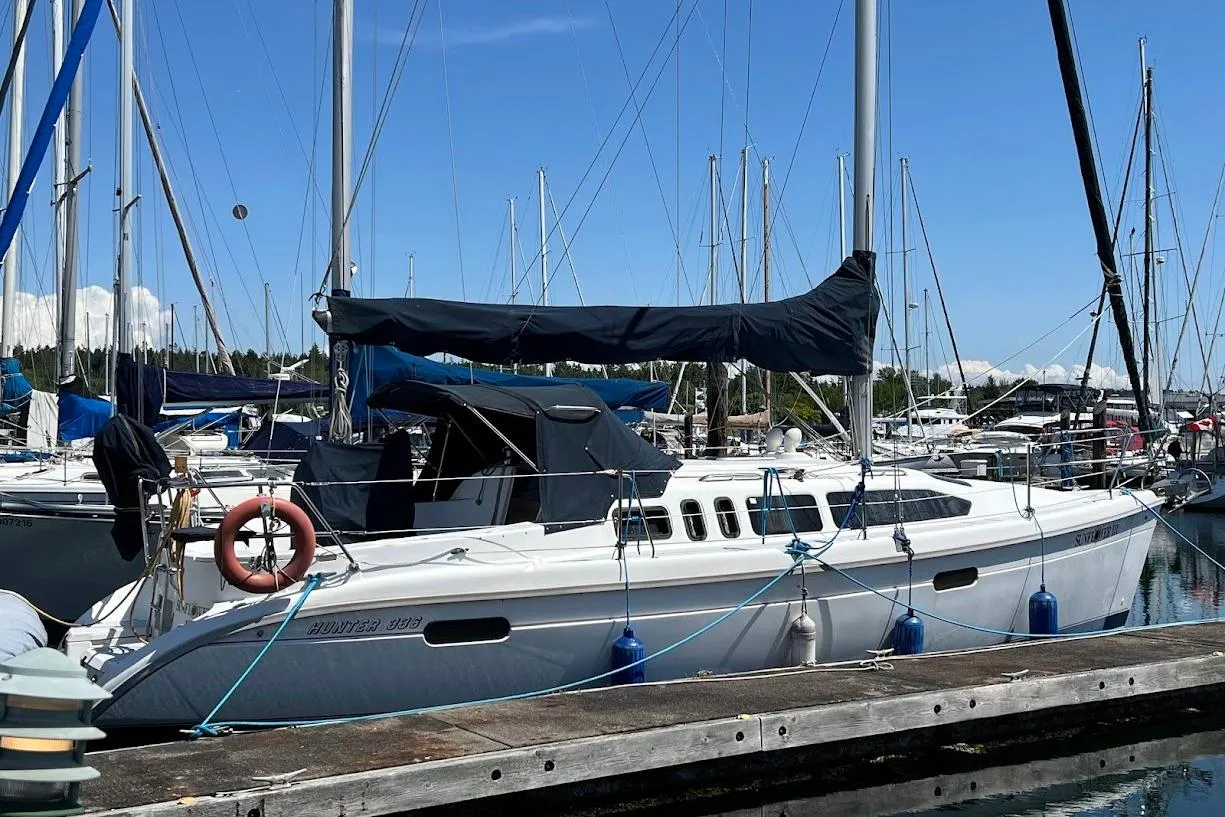Sailboat Hunter 336, 1995 model, docked at marina with clear blue sky.