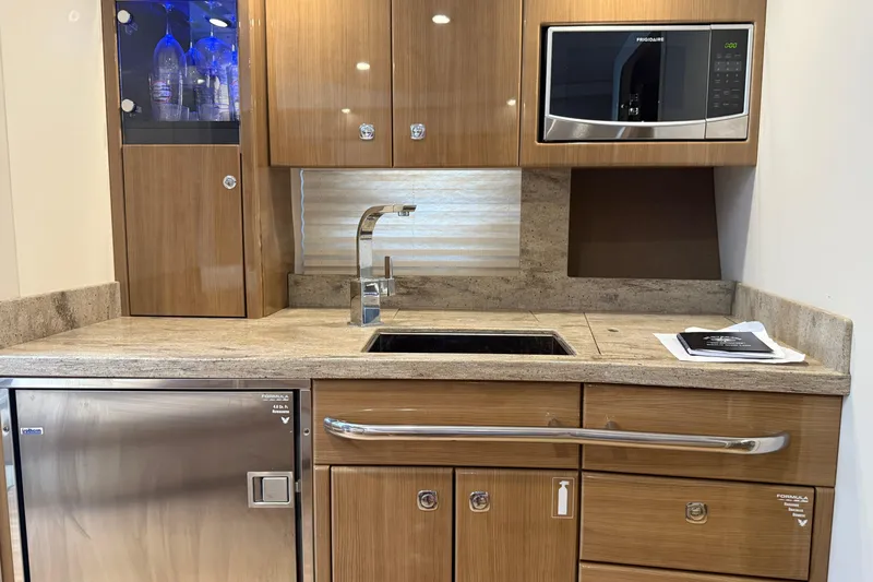 Another Six Pack Yacht Photos Pics Modern kitchen area in a 2016 Formula 37 Performance Cruiser with wood cabinetry and stainless steel appliances.