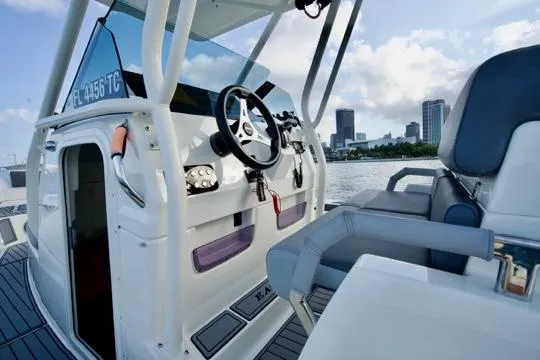  Yacht Photos Pics 2022 Brig Eagle 10 boat interior with steering wheel, city skyline in background.