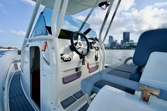  Yacht Photos Pics 2022 Brig Eagle 10 boat interior with steering wheel, city skyline in background.
