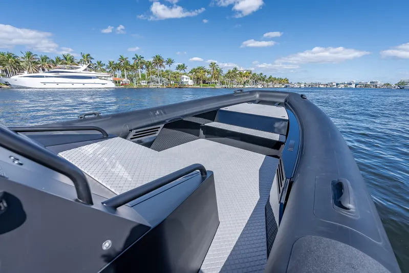  Yacht Photos Pics 2024 Goldfish X10 Scout boat on a sunny day with palm trees and a yacht in the background.
