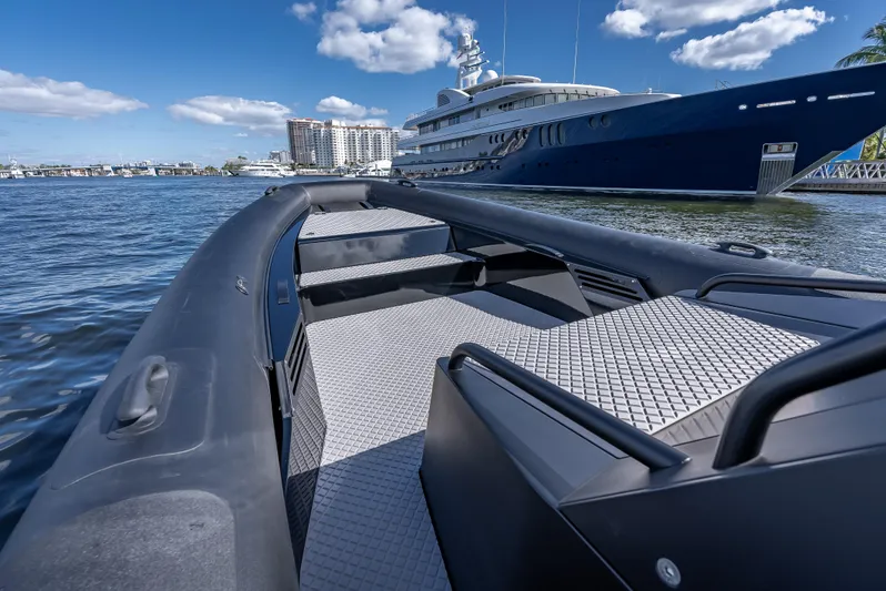  Yacht Photos Pics 2024 Goldfish X10 Scout boat on water with luxury yacht in background.