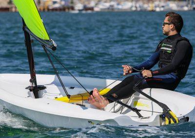 Man sailing 2024 RS Zest boat on blue water.