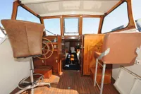 Interior of a vintage 1958 custom boat with wooden steering wheel and leather seats.