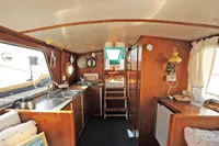 Interior of a vintage 1958 custom boat with wooden cabinetry and nautical decor.