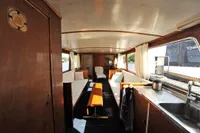 Interior of a 1958 custom boat with wooden furnishings and a cozy seating area.