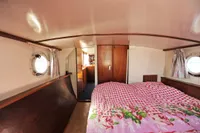 Interior of a 1958 custom boat with cozy bed and porthole windows.