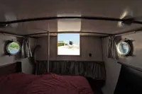 Interior of a 1958 custom boat cabin with portholes and curtains.
