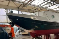 Custom 1958 boat in a workshop, featuring a sleek black and white hull design.