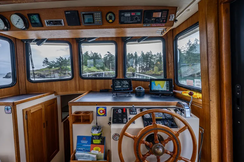Artemis Yacht Photos Pics Interior of a 1999 Nordic Tug 32 boat with navigation equipment and scenic window views.