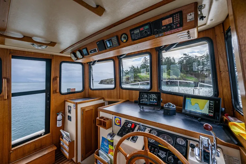 Artemis Yacht Photos Pics Interior of a 1999 Nordic Tug 32 boat with navigation equipment and scenic water view.