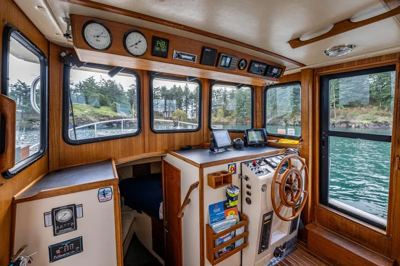 Artemis Yacht Photos Pics Interior of a 1999 Nordic Tug 32 boat with navigation equipment and scenic water view.