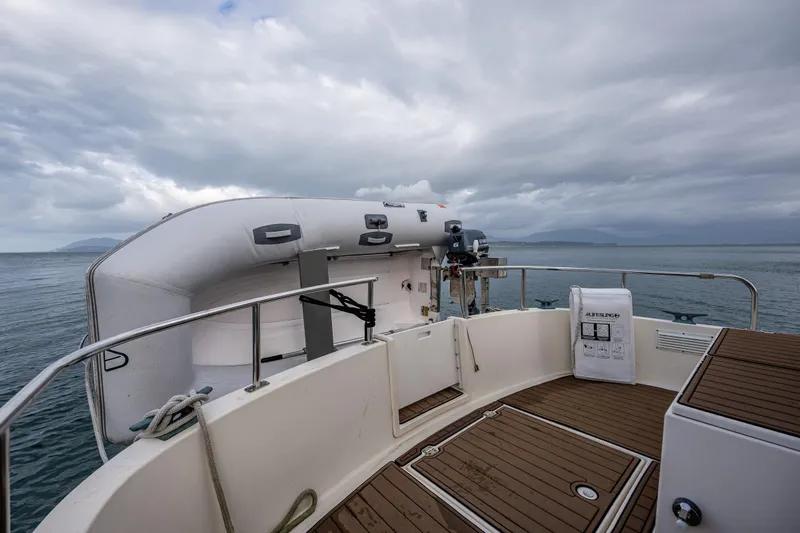 Artemis Yacht Photos Pics 1999 Nordic Tug 32 boat deck with inflatable dinghy and ocean view under cloudy skies.