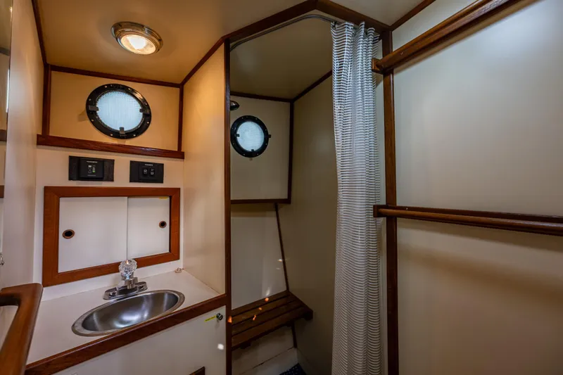 Artemis Yacht Photos Pics Bathroom interior of 1999 Nordic Tug 32 with sink, shower, and porthole windows.