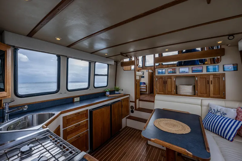 Artemis Yacht Photos Pics Cozy interior of 1999 Nordic Tug 32 with wooden cabinetry and ocean view.