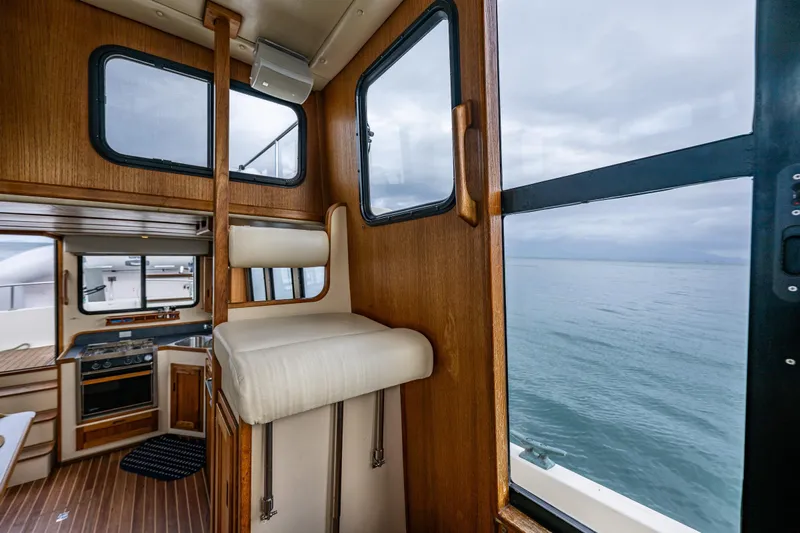 Artemis Yacht Photos Pics Interior of 1999 Nordic Tug 32, featuring wood paneling and ocean view through windows.