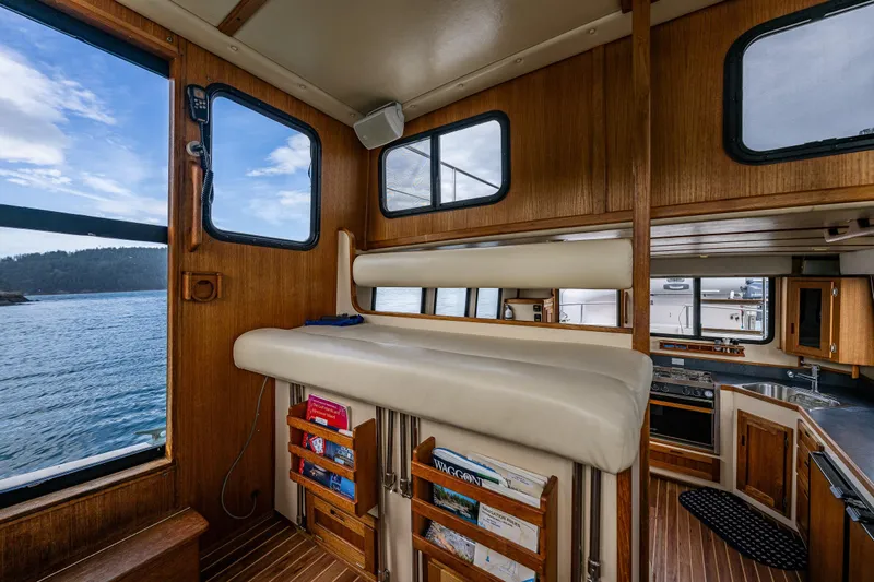 Artemis Yacht Photos Pics Interior of 1999 Nordic Tug 32, featuring wood paneling and scenic water view.