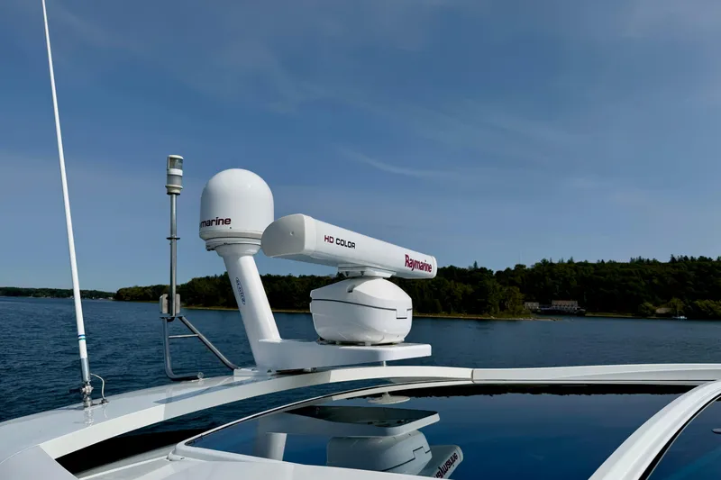  Yacht Photos Pics 2012 Cruisers Yachts 540 Sports Coupe radar system on calm waters, clear sky background.