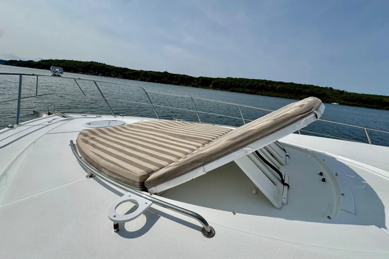  Yacht Photos Pics 2012 Cruisers Yachts 540 Sports Coupe with striped sunbed on deck, scenic water view.