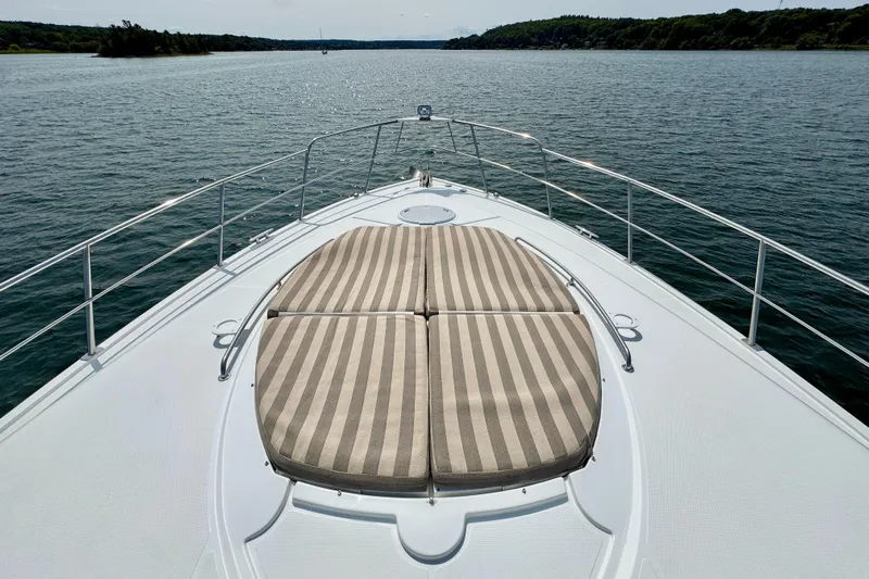  Yacht Photos Pics 2012 Cruisers Yachts 540 Sports Coupe on water, featuring striped sun pads on deck.