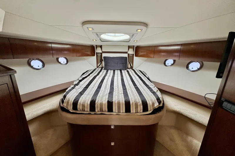  Yacht Photos Pics Luxurious cabin interior of 2012 Cruisers Yachts 540 Sports Coupe with striped bedding.