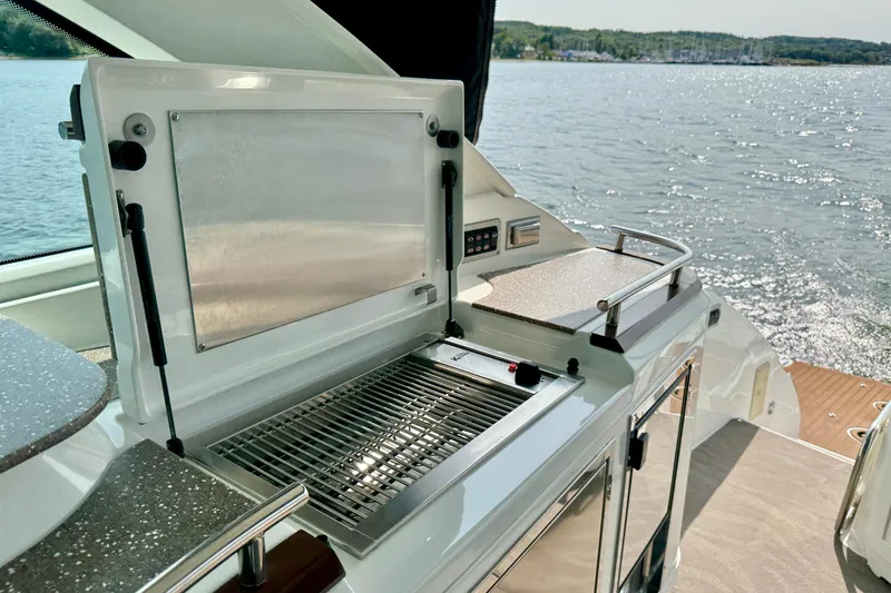  Yacht Photos Pics Outdoor kitchen on 2012 Cruisers Yachts 540 Sports Coupe, overlooking serene water.