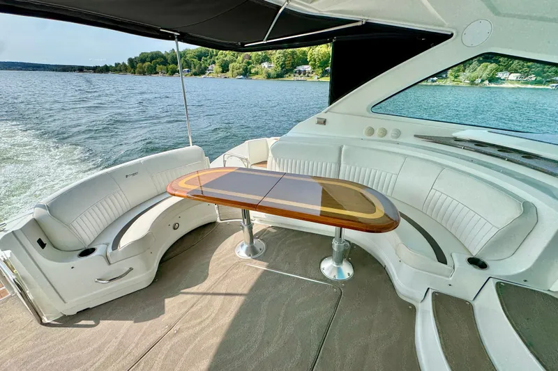  Yacht Photos Pics 2012 Cruisers Yachts 540 Sports Coupe interior with elegant seating and table on a serene lake.