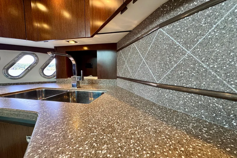  Yacht Photos Pics Luxurious kitchen interior of 2012 Cruisers Yachts 540 Sports Coupe with modern sink and porthole windows.